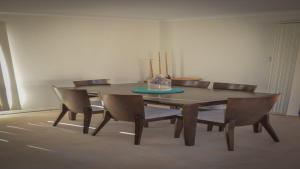 a dining room table with chairs and a cake on it at Lords Retreat in Coffin Bay