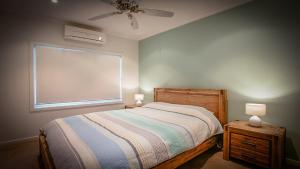 a bedroom with a bed and a window and a fan at Seasalt in Coffin Bay