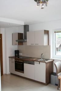 a kitchen with white cabinets and a sink at Ferienwohnung Leitner in Grins