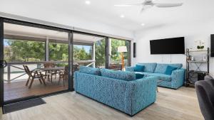 a living room with two blue couches and a table at The Boathouse in Coffin Bay