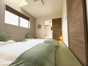 Postel nebo postele na pokoji v ubytování 大吉屋日赤館 名駅そばの一棟貸し