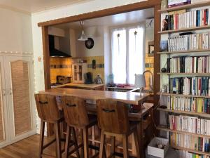 une cuisine avec une grande table en bois et quelques livres dans l'établissement Agréable maison de village avec jardin., à Beaulieu-sur-Dordogne