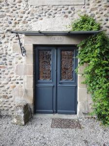 une porte bleue sur un bâtiment en pierre avec des plantes dans l'établissement Agréable maison de village avec jardin., à Beaulieu-sur-Dordogne