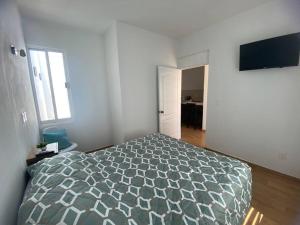 a bedroom with a bed in a white room at Departamento ‘El Bello’ en Palapa Ochoa in Loreto