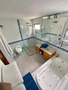 een badkamer met een douche, een wastafel en een bad bij Gran casa envigado jacuzzi, sauna y mirador in Envigado