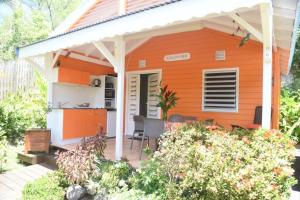 a small orange house with a kitchen in a garden at Les 3 épices in Le Gosier