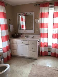 uma casa de banho com uma cortina de chuveiro com riscas vermelhas e brancas em The Red Mill House em Goldsboro