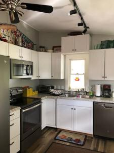 uma cozinha com armários brancos e um forno com placa de fogão em The Red Mill House em Goldsboro