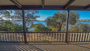 a view from the porch of a house overlooking the water at CDC-625 Beach House in Coffin Bay