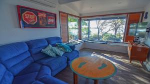 a living room with a blue couch and a table at CDC-625 Beach House in Coffin Bay