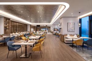an image of a restaurant with tables and chairs at Citadines Jinqiao Building Yantai in Yantai