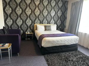 a bedroom with a bed and a couch and a chair at Best Western Wellington in Johnsonville