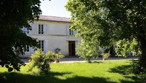 a large white house with a yard with trees at Le Vieux Noyer in Réaux