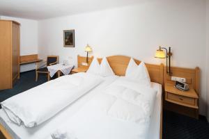 ein großes weißes Bett in einem Hotelzimmer in der Unterkunft Pension Schiessling in Anif