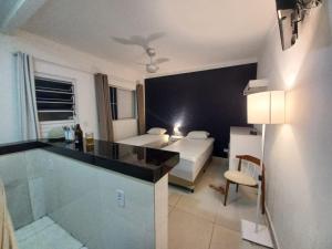 a hotel room with a bed and a bathroom at Suíte Studio 1 Enseada Tortuga Mobiliada in Guarujá