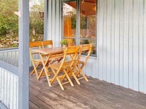 シーピンスリーにある4 person holiday home in K PINGSVIKの木製のテーブルと椅子が置かれたポーチ