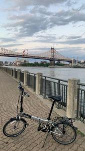 a bike parked next to a river with a bridge at Elegant 2 Bedrooms 14 minutes to Times Square! in Weehawken