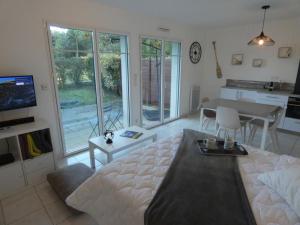 a living room with a bed and a table and a kitchen at Maison à Notre-Dame-de-Monts avec piscine, wifi et parking, 4 personnes - FR-1-540-145 in Notre-Dame-de-Monts