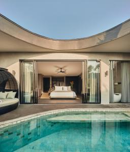 a villa with a pool and a bedroom at Je Ne Sais Quoi Seminyak in Seminyak