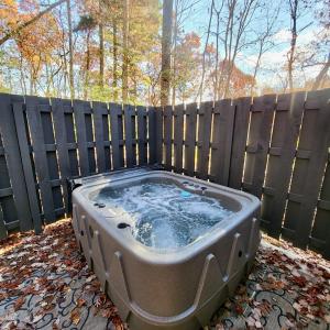 a hot tub sitting in front of a fence at Bigfoots Retreat chalet in Gatlinburg