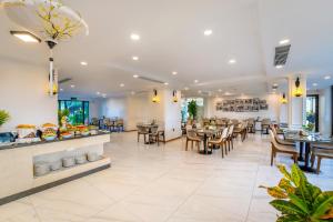 restauracja ze stołami i krzesłami oraz bufetem w obiekcie Athenia Boutique Hotel & Spa w Hoi An