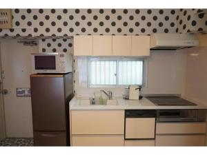 a kitchen with a refrigerator and a microwave at WALLABY HOUSE - Vacation STAY 38651v in Kawaguchi