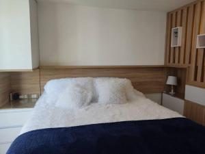 łóżko z białymi poduszkami w pokoju w obiekcie Loft 2019 La Candelaria estrenar 24/7 w mieście Bogota