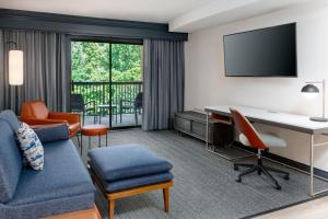 a hotel room with a desk and a couch at Courtyard by Marriott Danbury in Danbury