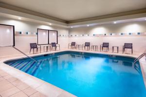 - une piscine avec des chaises et des tables dans une chambre d'hôtel dans l'établissement Courtyard by Marriott Danbury, à Danbury
