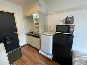 a small kitchen with a microwave on top of a refrigerator at Tokyo Stay Dolce in Tokyo