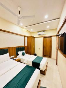 ein Hotelzimmer mit 2 Betten und einem TV in der Unterkunft HOTEL BKC DOWNTOWN - NEAR US EMBASSY in Mumbai