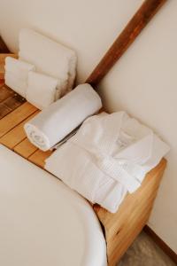 a shelf with towels and toilet paper on a bed at La Poza Boutique Hotel and Spa - Adults 15 plus in Todos Santos
