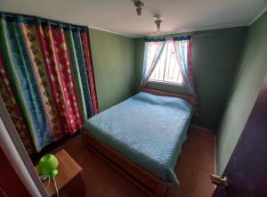 Cama pequeña en habitación con ventana en Cabañas Alma Changa Atacama en Caldera