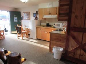 a kitchen with a white refrigerator and a table at The Woodsman Country Lodge Motel in Crescent