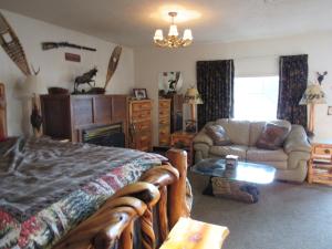 a bedroom with a bed and a couch and a table at The Woodsman Country Lodge Motel in Crescent