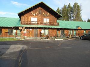 un gran edificio de madera con techo verde en The Woodsman Country Lodge Motel, en Crescent