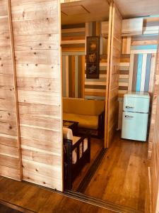 Habitación pequeña con sofá y nevera. en Surfer's Cafe& Hostel, en Chatan