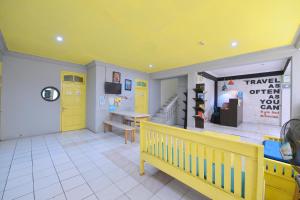 Habitación con puerta amarilla y banco en Bunk Bed and Breakfast, en Yogyakarta