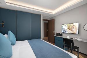 Habitación de hotel con cama y TV en la pared en Citadines Yunlong Lake Xuzhou en Xuzhou