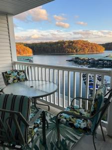 a balcony with a table and chairs and a view of the water at Condo at Parkview Bay - Your Lakefront Oasis in Osage Beach