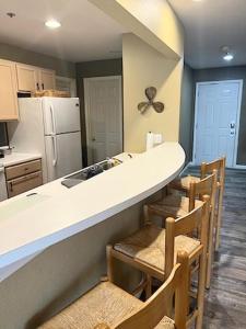 a kitchen with a counter and some chairs and a counter top at Condo at Parkview Bay - Your Lakefront Oasis in Osage Beach