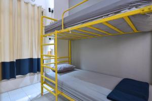 um beliche com uma escada amarela num quarto em Bunk Bed and Breakfast em Yogyakarta