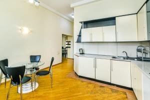 - une cuisine avec des placards blancs, une table et des chaises dans l'établissement SAHIL PARK 2 Bedrooms, à Baku