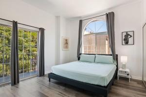 a bedroom with a bed and a large window at Modern loft close to Universal studio and Hollywood for 8 in Los Angeles