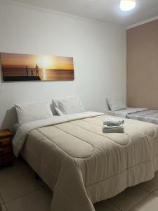 - une chambre dotée d'un grand lit avec une photo sur le mur dans l'établissement Villagio Aguas do Jaguari Pousada, à Santa Isabel