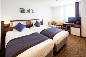 Habitación de hotel con 2 camas y TV de pantalla plana. en HOTEL MYSTAYS Kanazawa Castle en Kanazawa