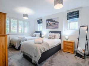 2 łóżka w sypialni z białymi ścianami i oknami w obiekcie Captains Rest w mieście Christchurch