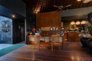 een eetkamer met een tafel en stoelen in een kamer bij Black Penny Villas Ubud in Ubud