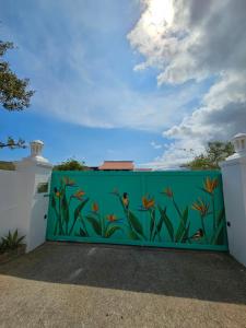 una valla verde con un mural de pescado. en Villa San Sebastian Curaçao en Fontein