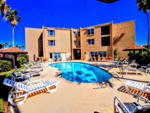 a swimming pool with lounge chairs and a building at Surfside I 310 Condominium Condo in South Padre Island
